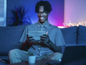 happy man using his tablet home couch