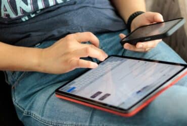 Handen die tekst typen op een Android-tablet met het schermtoetsenbord open
