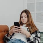 Tiener gebruikt een smartphone thuis