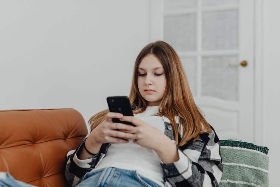 Tiener gebruikt een smartphone thuis