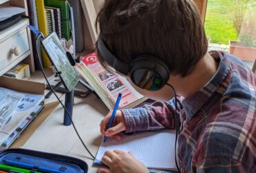 Kind met koptelefoon achter een tablet