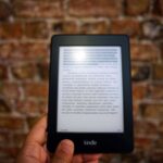 Hand die tekst selecteert en kopieert op het scherm van een iPad